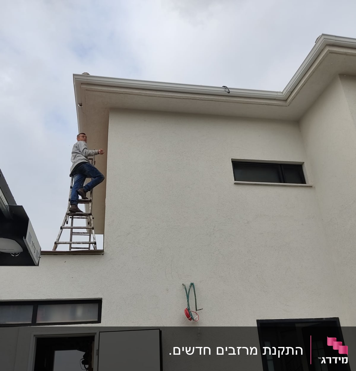 אדם על סולם ליד גג בית לבן